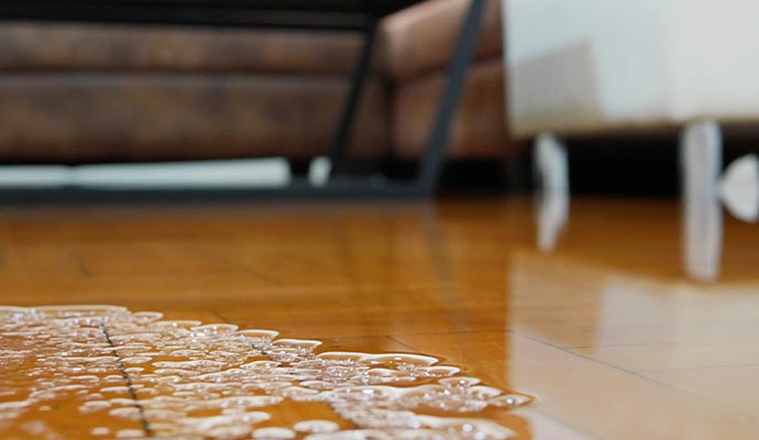 water flooding on living room parquet floor damage caused by water leakage